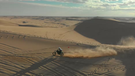 Aerial-of-desert-sand-dunes-with-motocross-riders-and-a-man-running