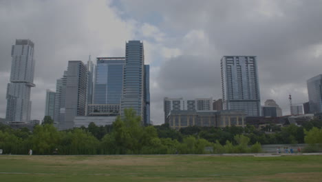 Locked-off-shot-of-Austin,-Texas-skyline-with-people-walking-in-background