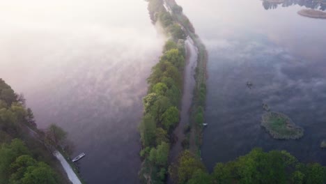 Luftaufnahme-Eines-Weges-Zwischen-Bäumen-Mitten-Im-See