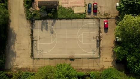 Empty-Outdoor-Basketball-Court-Pan-Up-Drone-Shot-in-the-Neighborhood