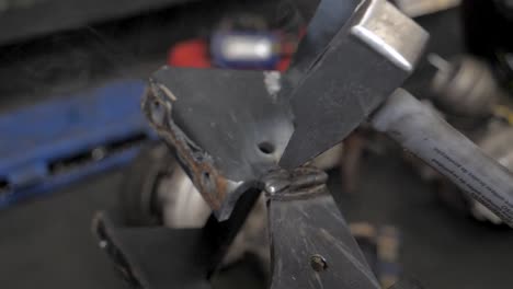 Knocking-with-a-hammer-in-slow-motion-in-a-mechanic-garage