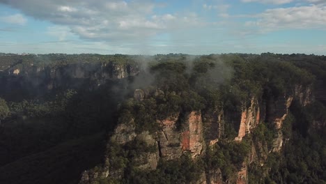 Aerial:-Drone-shot-moving-down-through-the-clouds-closer-towards-Sublime-Point-just-after-sunrise,-in-the-Blue-Mountains,-New-South-Wales