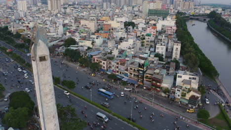 Evening-tilting-aerial-view-from-Dien-Bien-Phu-Bridge,-Binh-Thanh-district,-Ho-Chi-Minh-City,-showing-the-Hoang-Sa-canal-to-the-top-of-the-old-French-Colonial-incinerator