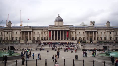 Tourists-and-street-artists-outside-the-National-Gallery-in-Trafalgar-Square,-London