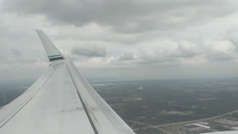 Blick-Aus-Dem-Flugzeug-über-Die-Tragfläche,-Während-Das-Flugzeug-An-Höhe-Gewinnt-Und-Durch-Die-Wolken-Fliegt
