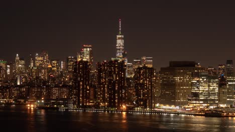 Time-Lapse-of-traffic-in-Manhattan,-New-York-City-on-three-levels,-Air,-Ground,-Water-at-night,-with-One-World-Trade-Center-in-the-center,-Waterside-Plaza-and-FDR-Drive-in-the-foreground-at-night