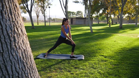 A-healthy-young-woman-stretching-her-legs-before-a-fitness-workout-in-the-park-at-sunset-SLOW-MOTION
