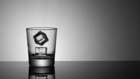 Slow-motion-ice-cube-drops-into-glass-with-water