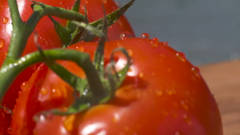 Macro-close-up-of-beautiful,-bright-red,-vine-ripened-tomatoes-dripping-with-water-in-the-summer-sun