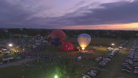 Aerial-View-of-a-Hot-Air-Balloon-Festival-at-Night-Firing-there-Propane-Creating-a-Night-Glow-on-a-Summer-Night
