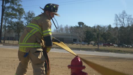 Firefighter-pulls-a-fire-hose-out-of-a-firetruck-to-get-ready-to-fight-a-fire