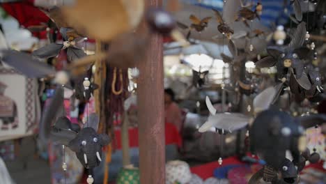 A-souvenir-shop-selling-different-designs-of-animal-inspired-wind-chimes-in-Luang-Prabang,-Laos---Close-up