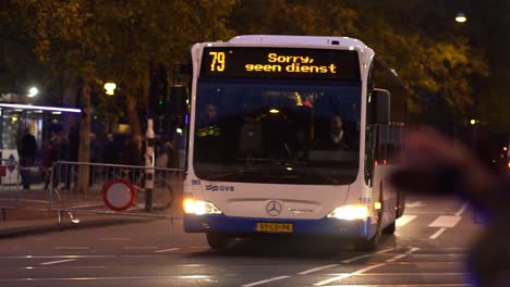 Polizist-Fährt-Auf-Einem-Motorrad-Mit-GVB-Busdienst-Nachts-Auf-Der-Straße-Während-Der-Klimademonstration-Der-Extinction-Rebellion-Group-In-Amsterdam,-Niederlande