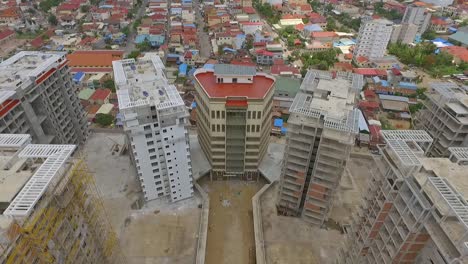 Tall-Building-Structures-Under-Construction-In-Phnom-Penh,-Cambodia---Aerial-Shot