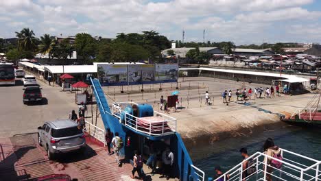 Footage-of-ferry-terminal-in-Davao-city-with-cars,-people-and-houses-in-the-background