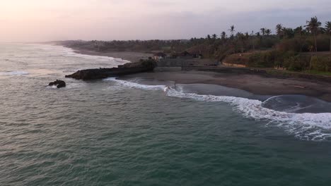 Der-Wunderschöne,-Unberührte-Pigstone-Strand-Auf-Bali,-Indonesien,-Unter-Einem-Violetten-Sonnenuntergang---Luftaufnahme