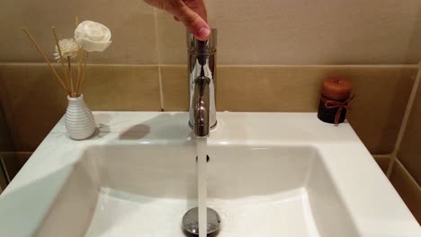 Running-water-from-luxury-bathroom-white-sink-in-hotel-room