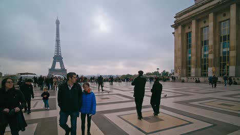 Tourists-on-an-overcast-day-walk-across-the-Palais-de-Chaillot-with-the-Eiffel-Tower-in-the-background,-Paris,-France