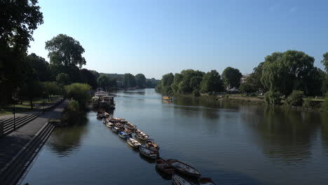 Shot-of-a-still-river-thames-with-a-boat-moving-slowly-in-the-distance,-on-a-bright-sunny-morning