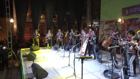 Wide-angle-shot-of-Mariachi-band-on-stage-with-harp-player-as-main-focus-in-Merida,-Mexico