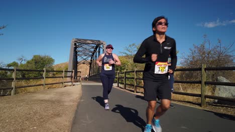 Men-and-women-runners-in-half-marathon-race-crossing-bridge-on-a-clear-day-in-Los-Angeles