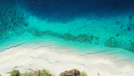 Bunte-Küste-Einer-Tropischen-Insel-Mit-Blauem,-Azurblauem-Meer,-Das-Den-Weißen-Sand-Eines-Exotischen,-Unberührten-Strandes-In-Turks--Und-Caicosinseln-Umspült