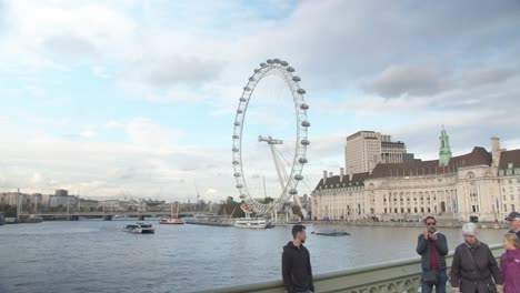 Tourists-observing-River-Thames,-London-Eye-and-County-Hall-cityscape