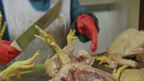 Ein-Marktverkäufer-Schneidet-Rohes-Huhn-Mit-Einem-Großen-Messer-In-Ollantaytambo,-Peru