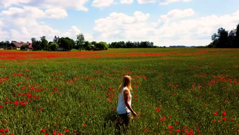 Young-Blonde-Woman-is-Walking-Through-a-Poppies-Field-Feeling-Happy