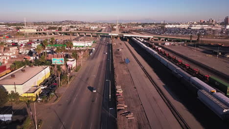 aerial-view-of-San-Pedro,-wide-noncrowded-road-in-industrial-zone,-shipping-industry-and-rail-yard