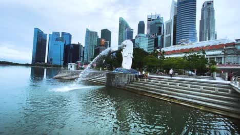 Merlion-Statue-Fountain-With-Tourists-And-Downtown-Skyline-On-The-Background