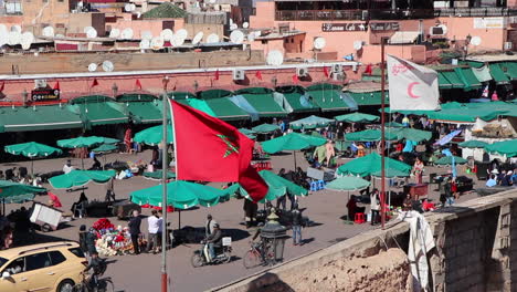 Marokkanische-Flagge-Weht-über-Einem-Belebten-Händlermarkt-In-Marrakesch,-Marokko