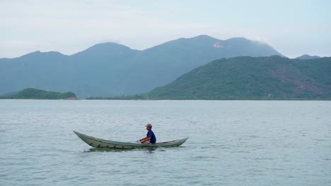 Hombre-Vietnamita-Local-Paseo-En-Bote-Pequeño-Frente-A-La-Costa-De-Nha-Trang