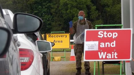 Army-nurse-wearing-face-mask-guiding-vehicles-at-corona-covid-virus-test-centre-shelter