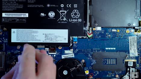 Computer-technician-repairing-laptop-motherboard