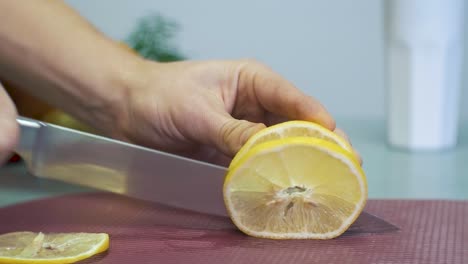 Man-cutting-yellow-lemon-with-knife-on-chopping-board-white-background-with-fruits