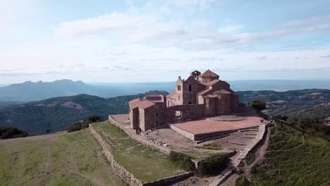 Drone-zoom-out-shot-of-a-church-in-the-top-of-the-mountains-in-Catalonia,-Spain