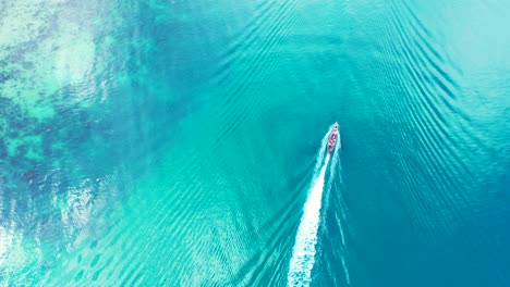 Boot-Segelt-über-Ruhiges,-Klares-Wasser-Des-Blauen-Türkisfarbenen-Meeres,-Das-Das-Sonnenlicht-In-Der-Nähe-Der-Küste-Einer-Tropischen-Insel-In-Malaysia-Reflektiert