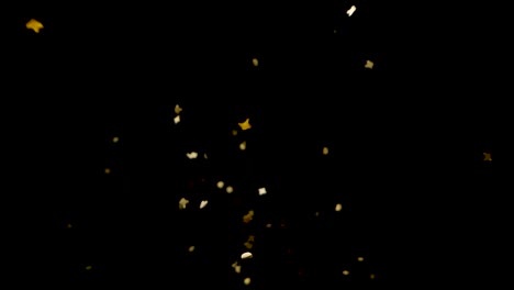 Slow-motion-golden-confetti-drops-from-above-onto-camera-lens
