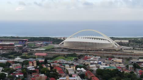 Moses-Mabhida-football-stadium-and-Kings-Park-stadium-in-Durban,-by-the-Indian-Ocean