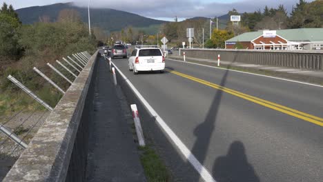 Vehicles-Passing-By-On-The-SH1-Bridge-In-Turangi,-New-Zealand-During-Ski-Season---long-shot