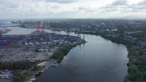 Haina-Port-Full-of-shipping-containers-and-large-cranes-sitting-on-the-river-on-an-overcast-day