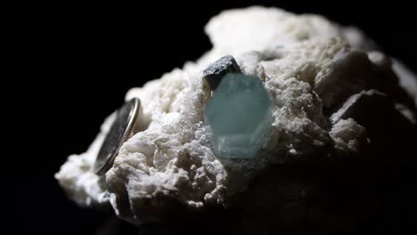 A-single-aquamarine-crystal-in-a-matrix-of-feldspar-with-a-dime-as-a-size-reference