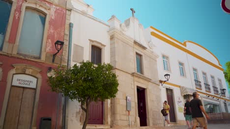 Portugal-Algarve-Loule-narrow-stone-street-with-pedestrians-walking-at-morning-sunshine-4K