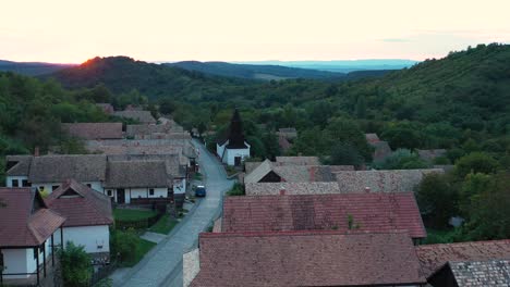 Drone-flies-over-the-historical-streets-of-Holloko,-Hungary-in-the-sunset