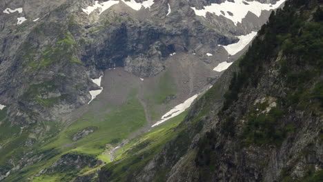 Detailaufnahme-Eines-Grünen-Tals-In-Den-Alpen,-Das-Den-Permanenten-Schnee-Des-Gletschers-In-ProRes-4K-Enthüllt