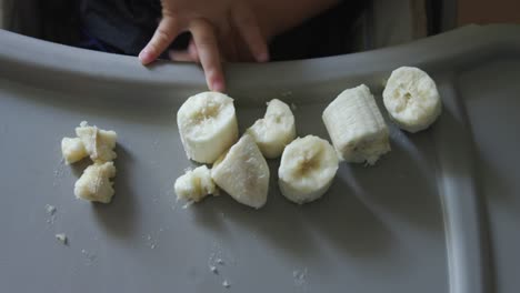 Baby-playing-with-banana-pieces