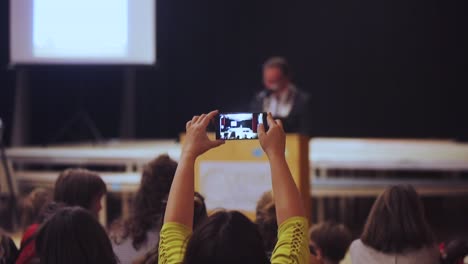 A-Female-Participant-Filming-A-Presentation-During-The-Youth-Conference-In-Waldorf-School-In-Netherlands---Rack-Focus