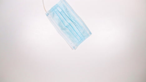 Medical-Face-Mask-Lies-On-White-Tabletop---Disposable-Facemask