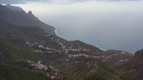 Un-Pequeño-Pueblo-De-Montaña-En-La-Costa-Atlántica-De-La-Isla-De-Tenerife-Con-Los-Afilados-Picos-De-Las-Montañas-Distantes-Escondidos-En-Nubes-Tormentosas